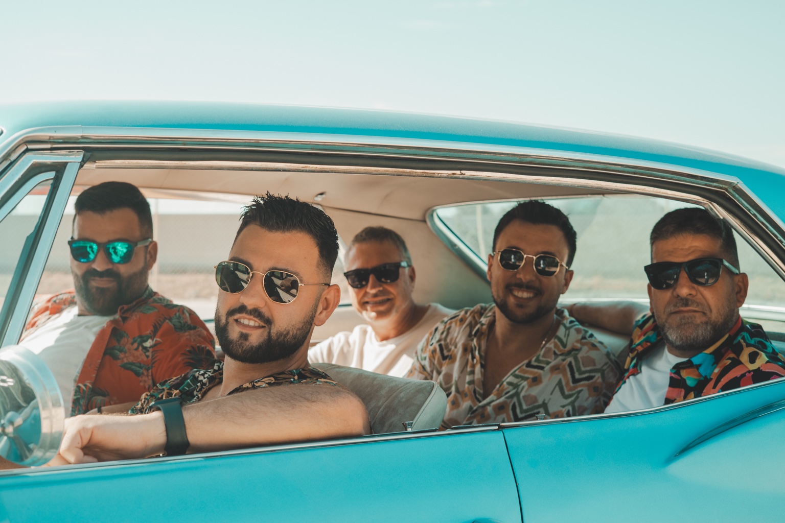 Los cinco miembros de Va de Rumba en un coche azul